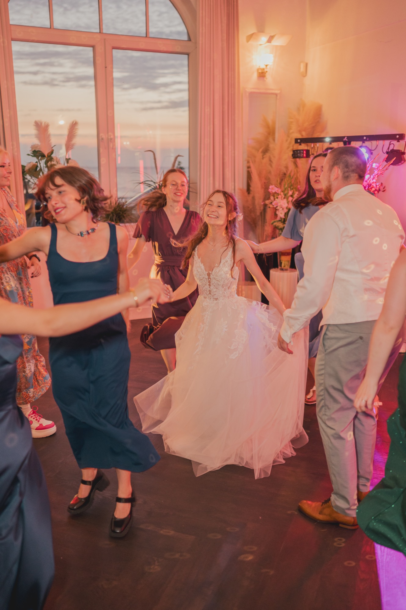 Polnischer Abgang auf der Hochzeit – warum ihr euch am besten gar nicht verabschiedet 4 Hochzeitsgäste tanzen am Abend im Meergut Hotel Kühlungsborn mit Blick auf die Ostsee